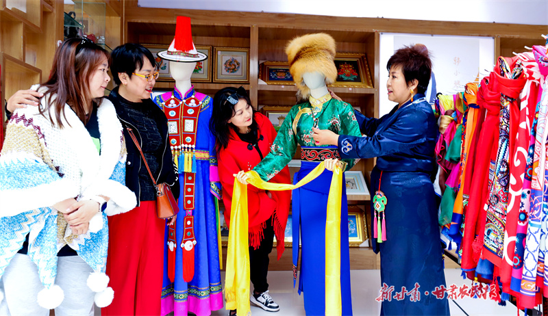 非遗传承人在向游客介绍藏族、裕固族服饰